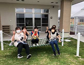 屋外テラスで入居者がレクリエーション活動を楽しんでいる風景